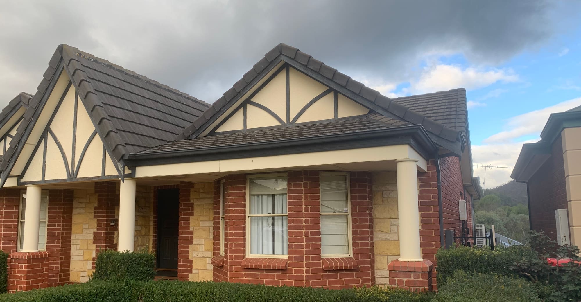 A well-kept Adelaide home with storm clouds rolling in behind it